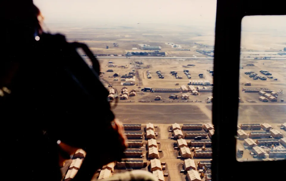 A camp seen from the air, photographed from a helicopter with a camera in hand